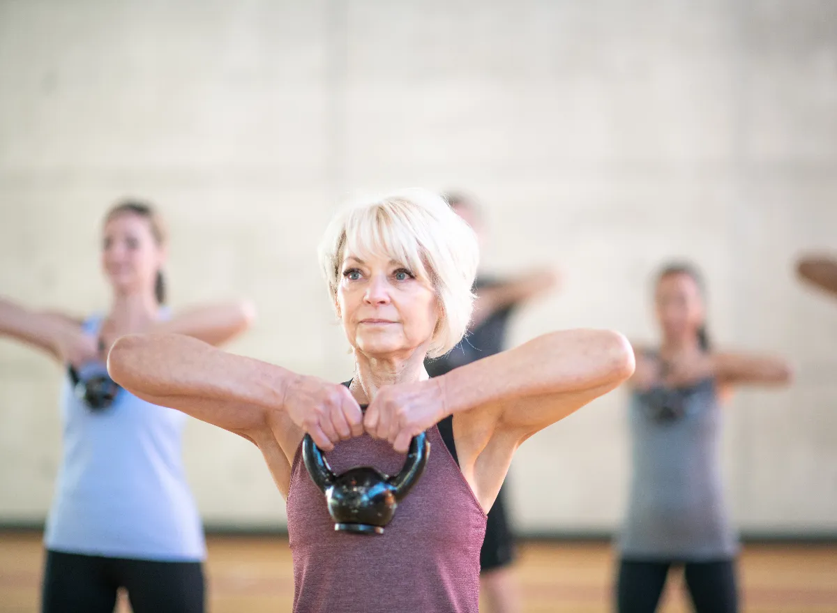 older woman lifting kettlebell